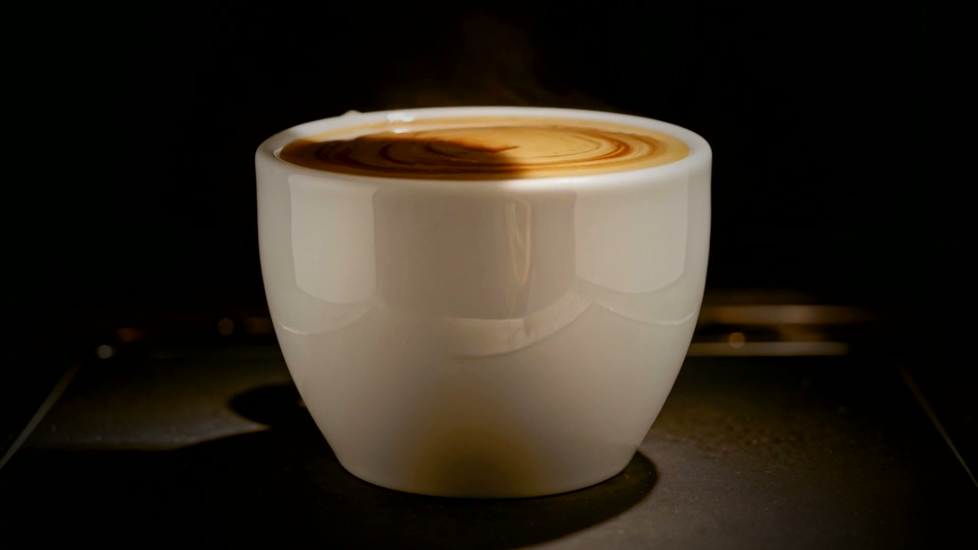 A finished espresso, crema settled, resting under a single warm light.