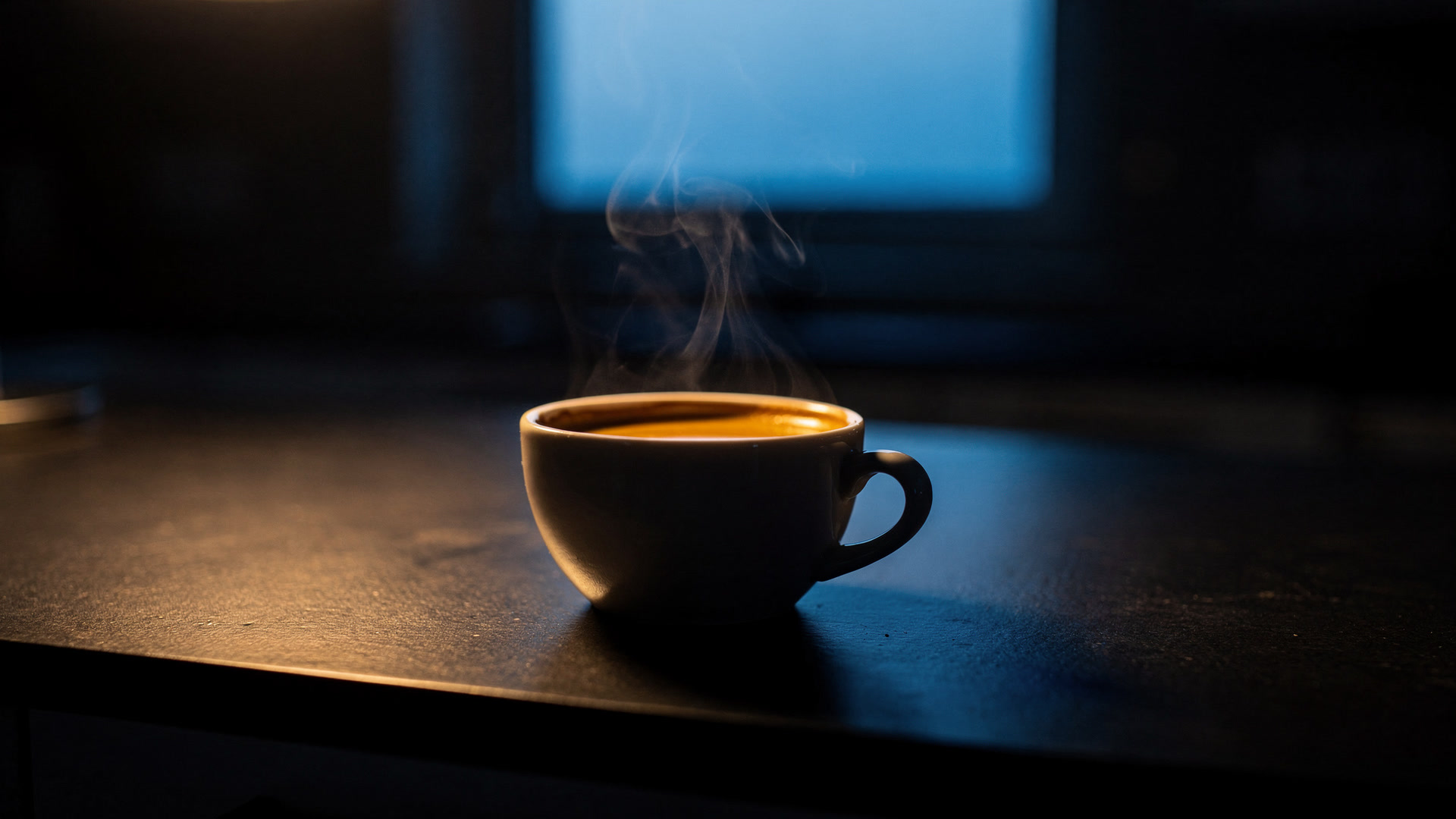 An espresso steaming on a dark counter with first light at the window.